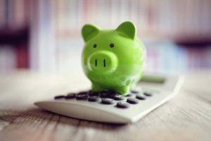 Saving Costs Green Piggy Bank On A Calculator